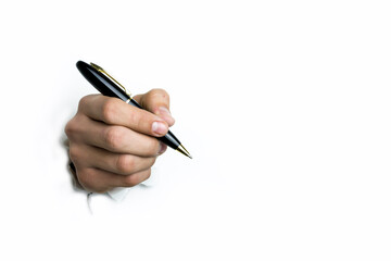 The hand holds a black ballpoint pen on a white background.