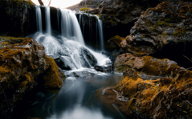Fototapeta premium waterfall in the forest the backdrop of rocks