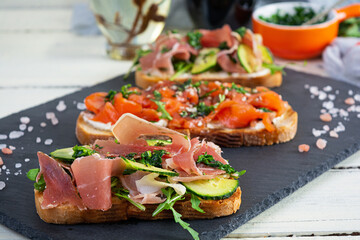 Grilled bruschetta with salmon fillet and jamon. Delicious Italian bruschetta antipasti