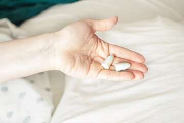 sleep insert, earplugs in hand to protect sleep from sounds and noise