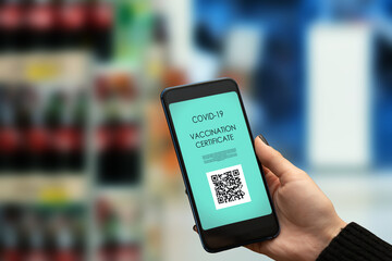 Fototapeta na wymiar proof of vaccination for a grocery store,hand with qr code on phone to visit supermarket