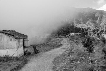 Dramatic black and white image of a small village 8000 feet high in the Caribbean mountains of the Dominican Republic, with misty fog.