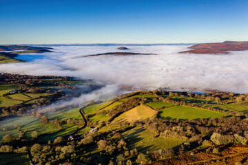 Aerial view of low level fog and cloud in a valley in the rural Brecon Beacons, Wales