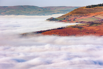 Mountains and trees showing through low level fog and cloud inversions in the Brecon Beacons, Wales