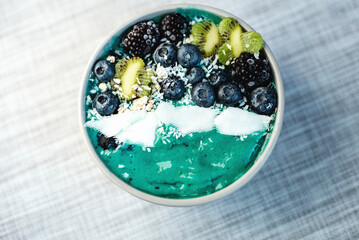 Healthy breakfast berry, banana smoothie bowl topped with Blueberries and chia seeds, blackberries, kiwi, coconut delicious blueberry smoothie bowl. vegan raw food. Selective focus. copy space.