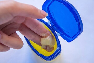 Woman using petroleum jelly for skincare.