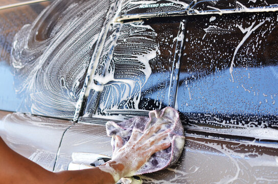 Man hand washing a gray vehicle stock photo
