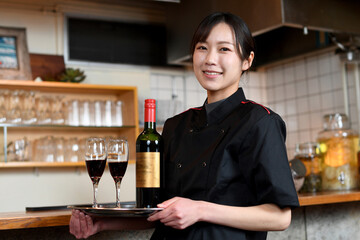レストラン（飲食店）で働くアジア人の女性の店員（カメラ目線）
