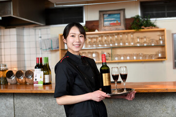 レストラン（飲食店）で働くアジア人の女性の店員（カメラ目線）
