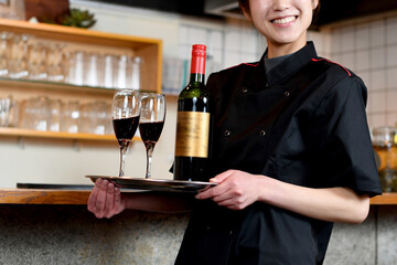 レストラン（飲食店）で働くアジア人の女性の店員（カメラ目線）
