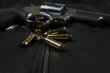 44 magnum ammunition and revolver, black leather jacket closeup
