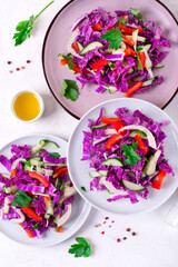 Salad with red napa cabbage, bell pepper, cucumber and fennel served in three ceramic plates. Healthy vegan lunch. Top view