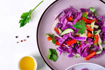 Salad with red napa cabbage, bell pepper, cucumber and fennel on the ceramic plate. Healthy vegan meal. Top view