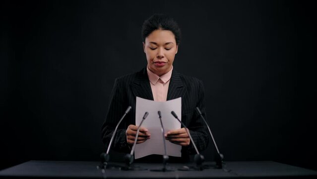 Nervous black female press secretary reading speech from paper, stressful job