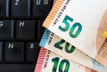 euros paper money on laptop keyboard.. Macro close up photo