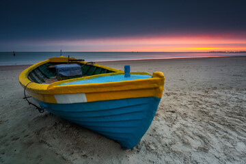 Fishing boat at sunrise on the Baltic Sea beach in Sopot. Poland