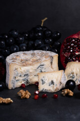 Gorgonzola blue mold cheese with pomegranate, grapes and nuts.