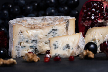 Gorgonzola blue mold cheese with pomegranate, grapes and nuts.