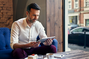 Businessman using digital tablet in cafe