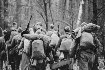Re-enactors Dressed As World War II Russian Soviet Red Army Soldiers Marching Through Forest In...