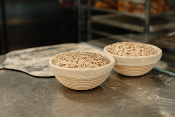 Fresh raw dough in wooden molds on the table before baking homemade bread.