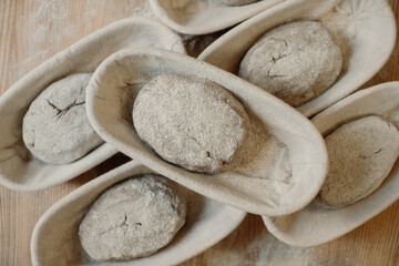 Fresh raw dough in wooden molds on the table before baking homemade bread.