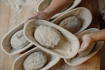 Fresh raw dough in wooden molds on the table before baking homemade bread.