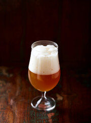 Glass of Wheat Beer on dark wooden background. Copy space.	