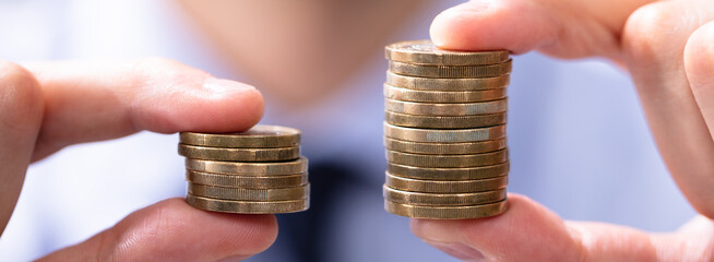 Man Comparing Two Coin Stacks