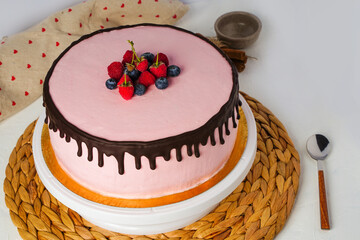Homemade sponge cake with berries, pink cream and chocolate. Selective focus.