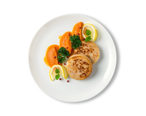 Fish cutlets with a vegetables  puree served whit lemon slice on the white plate isolated on white background. Top view