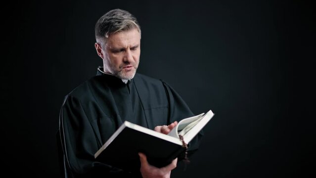 Catholic priest reading Bible while preaching after church service, spirituality