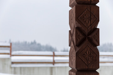 View from the gazebo with carved wooden poles on the winter forest and mountains. Carved wooden...