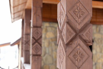 View from the gazebo with carved wooden poles on the winter forest and mountains. Carved wooden...