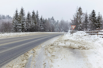 Winter snow-covered highway, cleared and sprinkled with sand and salt by road services.