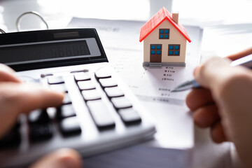 Person Hand Calculating A Real Estate Property