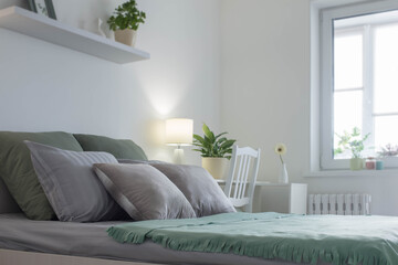 white bedroom with gray and green linens