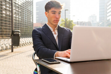 Fototapeta premium Young entrepreneur working on his laptop in a cafe. Digital entrepreneurship concept.
