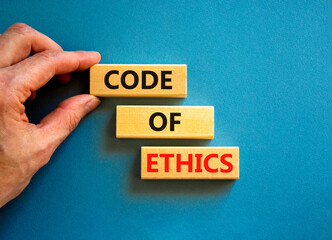 Code of ethics symbol. Concept words Code of ethics on wooden blocks on a beautiful blue table blue...