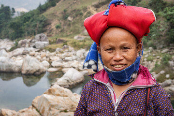 Cheerful Red Dao ethnic minority woman wearing typical headgear and smiling near Sapa, Lao Cai,...
