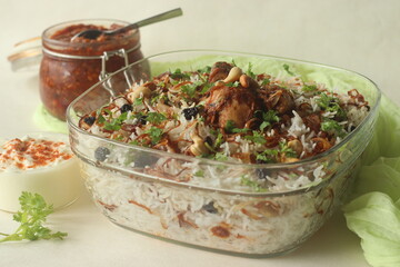 Ghee rice and chicken roast. A rice dish made of basmati rice, ghee, spices and garnished with fried onions, cashews and raisins. Served with kerala style spicy chicken roast