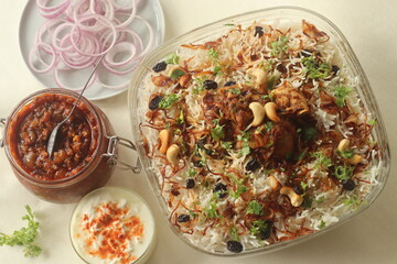 Ghee rice and chicken roast. A rice dish made of basmati rice, ghee, spices and garnished with fried onions, cashews and raisins. Served with kerala style spicy chicken roast
