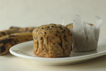 Plantain muffins. A healthy snack with extra ripe plantains, whole wheat flour and sesame seeds as the ingredients. Shot with muffins inside parchment paper cups