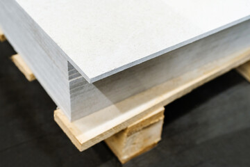 A stack of gypsum boards on a wooden pallet. Trade and delivery of building materials. Selective...