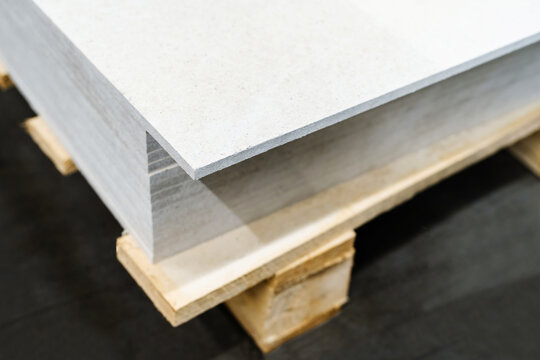 A stack of gypsum boards on a wooden pallet. Trade and delivery of building materials. Selective focus. Close-up