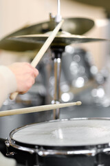 Young adult men and women learn to play drums at school. Hobbies and pastime.