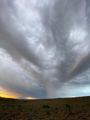 storm clouds and rain over the field at sunset