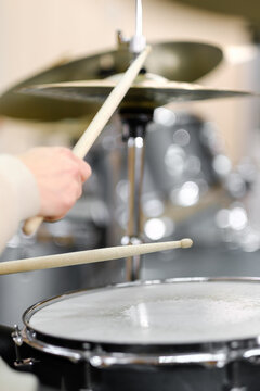 Young adult men and women learn to play drums at school. Hobbies and pastime.
