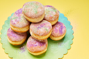 Mardi Gras donuts sprinkled with colorful powdered sugar.