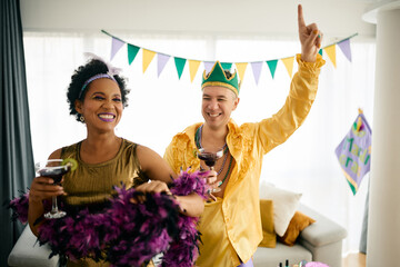 Happy multiracial friends dancing and having fun at the party during Mardi Gras celebration.